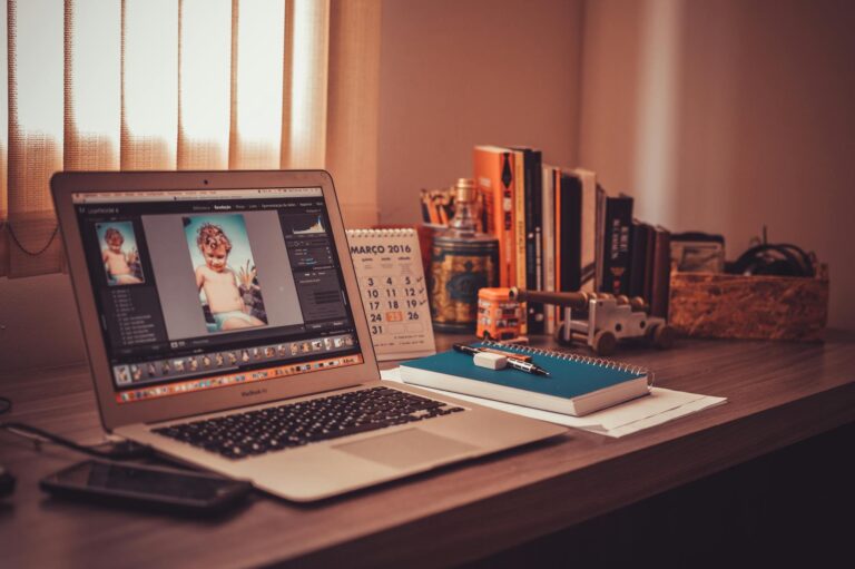 turned on screen silver macbook air on wooden desk